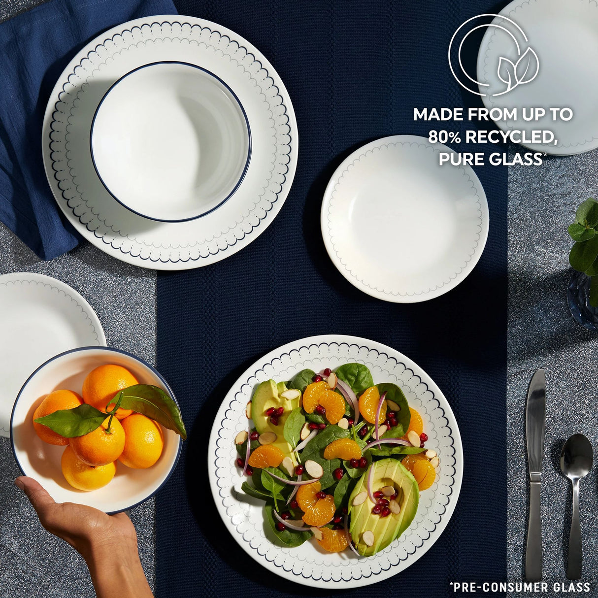 Caspian Lace Dinnerware on tabletop with text made from up to 80% recycled pure glass
