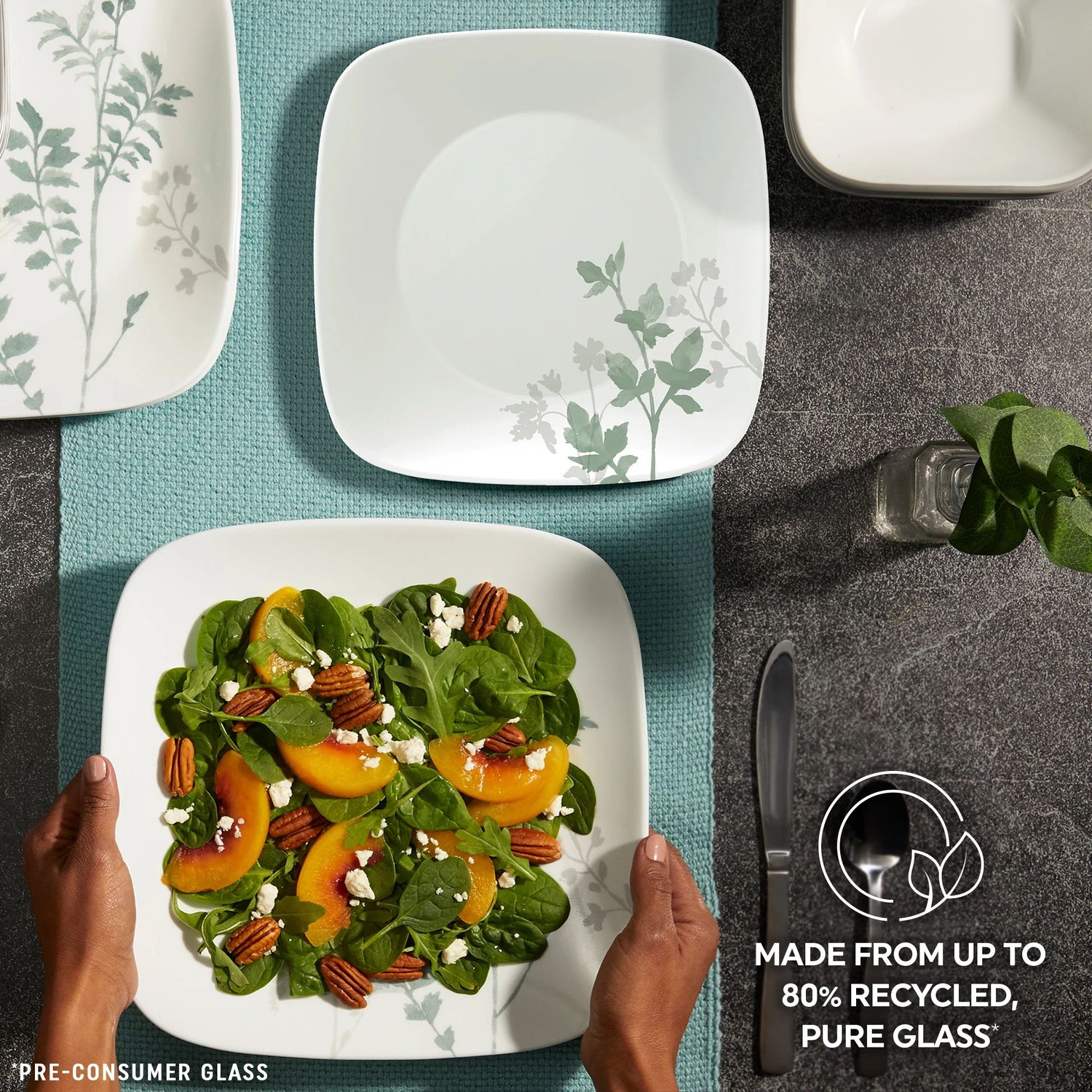 Square Amalie Dinnerware Set on table top with text made from up to 80% recycled pure glass