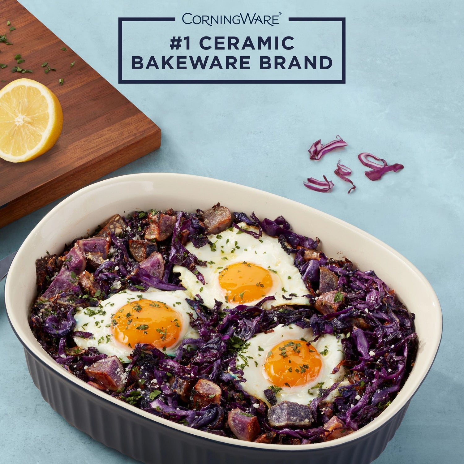 French Colors 2.5-quart Oval Baking Dish, Navy with food inside and text #1 ceramic bakeware brand