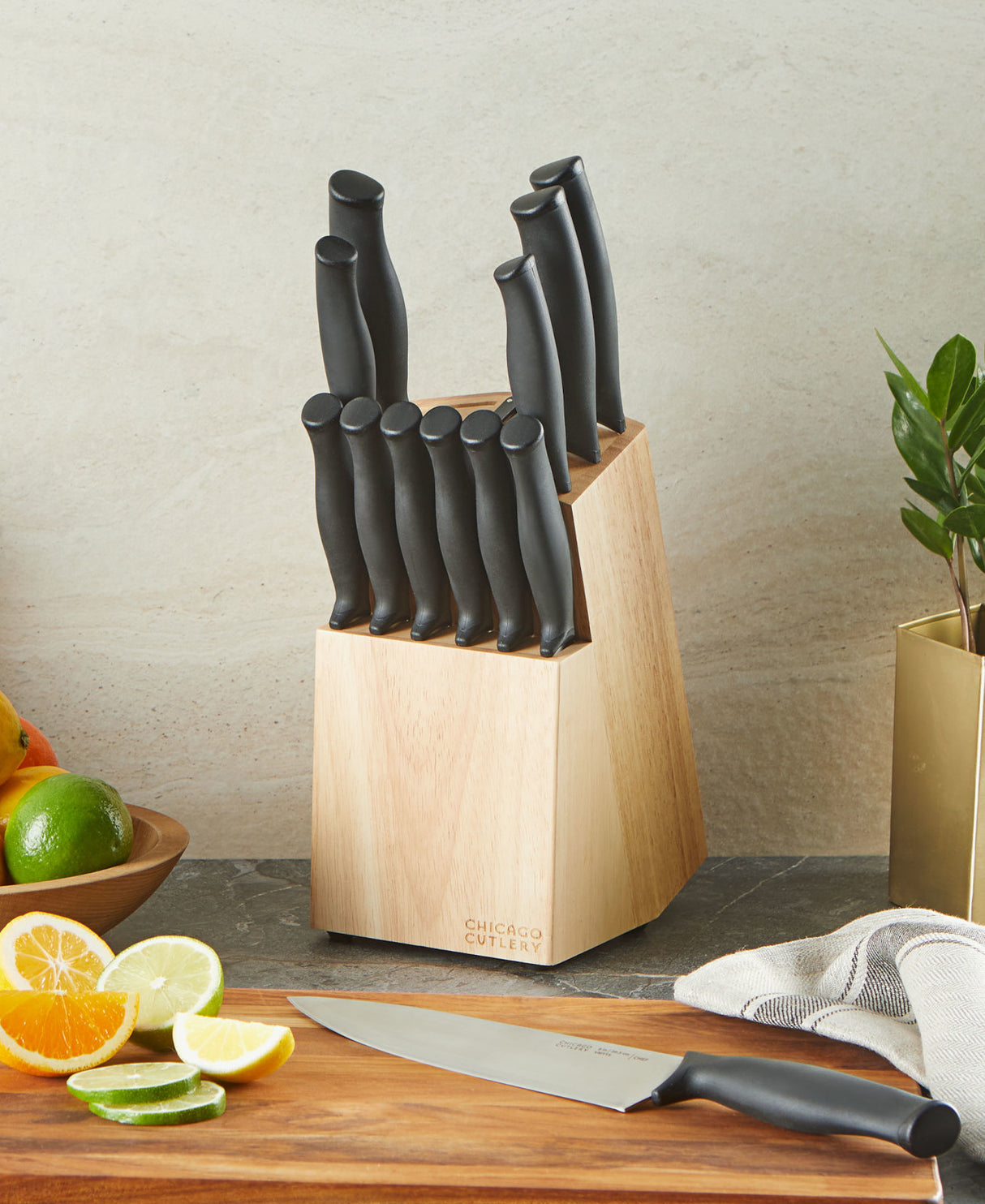 Chicago Cutlery Belmont 13pc Block set with Chef Knife in front on cutting board with lime and oranges