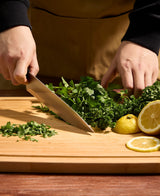 Belmont Chef knife being used to cut parsley on cutting board