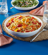  spaghetti with tomatoes in bowl on table.
